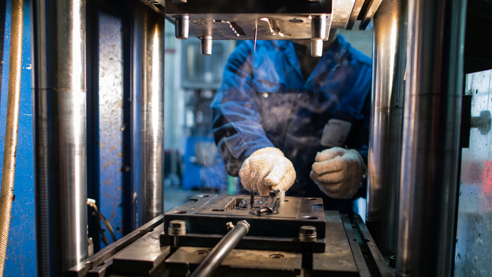 Ouvrier en train de travailler sur une machine pour les élastomères